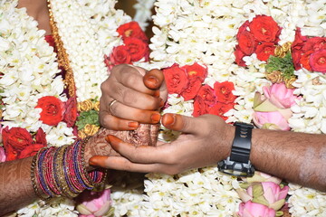 Tamil brahmin couple on their wedding day, holding hands as per south indian culture