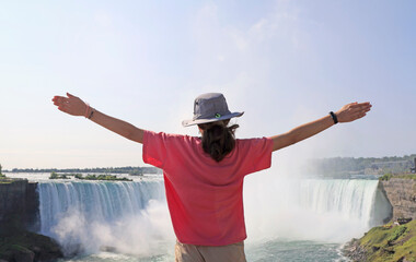 Teenager girl enjoying the panoramic view of Niagara Falls in summer, Canada