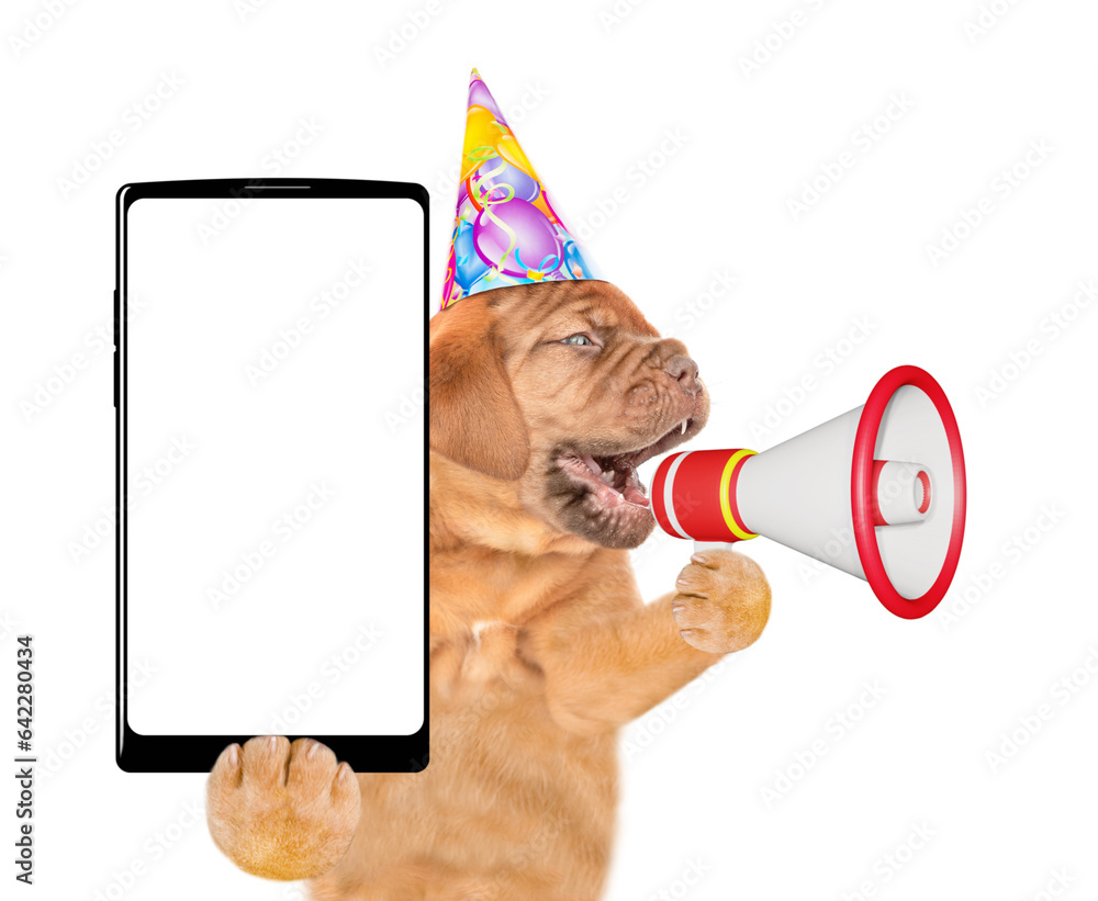 Poster mastiff puppy wearing party cap screaming into a megaphone and holds smartphone with blank screen. i