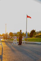 A security guard is controlling the traffic and parking situation at an Asian festival in Canada.