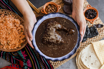 mexican woman cooking mole poblano sauce with chicken traditional food in Mexico Latin America - obrazy, fototapety, plakaty