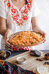 Mexican woman cooking red rice with ingredients, traditional food in Mexico Latin America