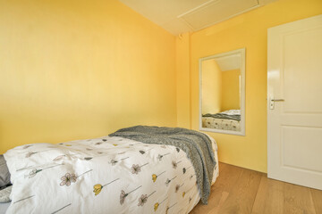 a bedroom with yellow walls and wood flooring in the fore - image is taken from another room to the right