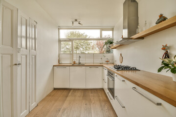 a kitchen with white cabinets and wood counter tops on the counters in front of the sink is open to the outside