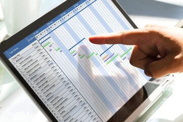 Businessman analyzing gantt chart on laptop