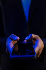 Vertical image of hands of biracial businessman with smartphone with copy space on black background