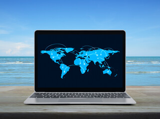 Connection line with global world map on laptop computer monitor screen on wooden table over tropical sea and blue sky, Business communication online concept, Elements of this image furnished by NASA
