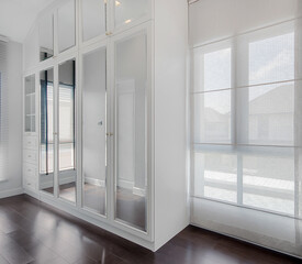Modern white built-in wardrobe of bedroom interior
