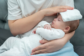 Obraz na płótnie Canvas Wet towel comforts a feverish infant, Concept of mother's instinctive care response
