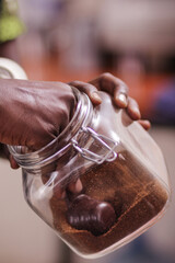 close up of chocolate Grounded coffee beans hands sorting out red coffee maker machine equipment metal in the kitchen in Nairobi City County Kenya East Africa	