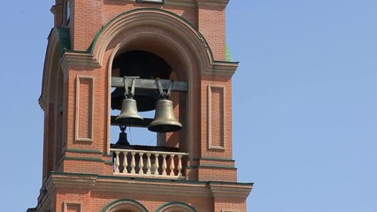 Bell tower of a brown orthodox church. Vertical panning shot of a bell tower of the orthodox church made of brown bricks. There are golden domes and crosses on top - Powered by Adobe