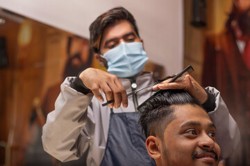 Young man cutting hair at the modern barber shop