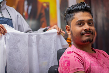 Young man cutting hair at the modern barber shop