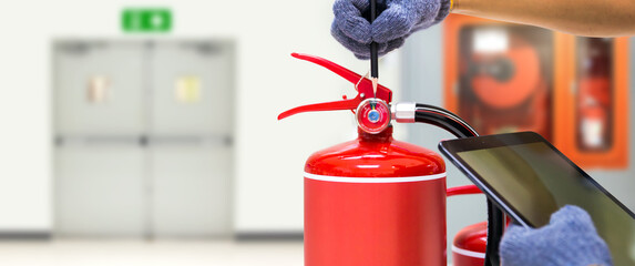 Fire extinguisher has hand engineer checking pressure gauges with exit door to prepare fire...