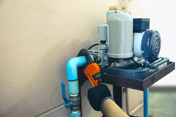 Technician plumber using a wrench to repair a water pump pipe. Concept of maintenance, fix water...