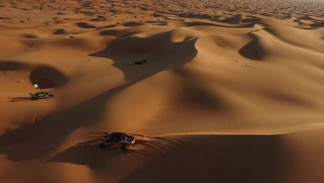 Buggies drive through the desert. Drone video. Several buggies drive one after another across the desert.UAE. Drone video