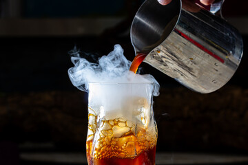 Whisky Smoke. Smoking whiskey with ice and orange on a dark background. Cognac with smoking branch of lavender.