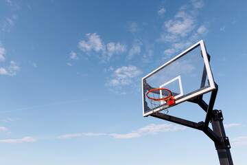 A new basketball hoop against a clear blue sky. The concept of urban sports. Ideal for conveying the excitement of outdoor play, sports catalogs and lifestyle publications.