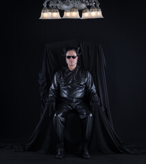 portrait of a male devil with horns on a black throne