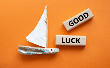 Good luck symbol. Wooden blocks with words Good luck. Beautiful orange background with boat. Business and Good luck concept. Copy space.