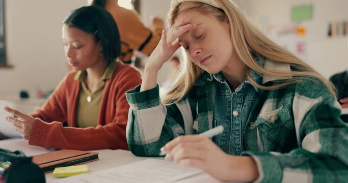 Headache, student and anxiety for test in classroom with stress for assessment, learning and scholarship at school. Exam, college and girl with burnout of studying for knowledge and development