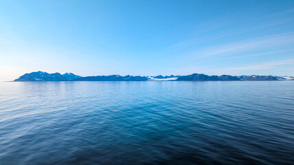 View of glaciers on the coast in Svalbard on a sunny day with calm sea - Landscape Photography
