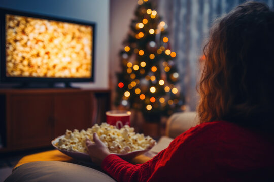Woman Immersed in TV with Popcorn on Christmas