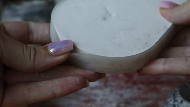 Close-up of the silicone mold and the plaster base in it. The master removes the plaster stand. High quality video
