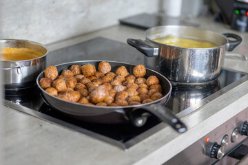 A stove with Swedish meatballs, potatoes and brown gravy