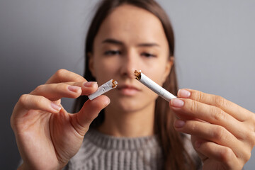 stop nicotine, teenager breaks a cigarette, refusal of smoking of minors