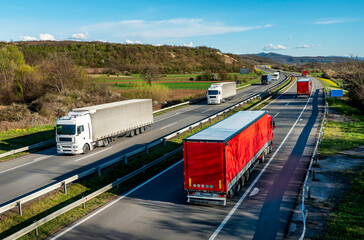 Heavy Highway transportation scene with Convoys or fleets of transportation trucks in both ways,on...
