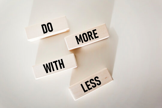 Conceptual words Do more with less on wooden blocks and white background. Copy space.