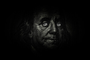 Ben Franklin's face with glowing eyes on the old US $100 dollar bill. Macro grunge style photo....