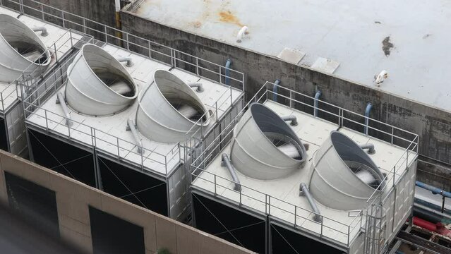 Cooling towers in data center building. Air conditioning cooling towers in front of building with fins to the front. Industrial cooling towers or air cooled water chillers with piping system.	