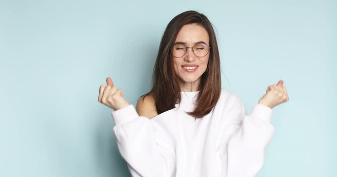 Amazed excited woman hairstyle in white sweater cover and open mouth in surprise looking at camera with big eyes, shocked. Indoor studio shot isolated on blue background. Oh my god wow, yes gesture.