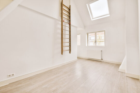 Empty mansard room with window and radiator