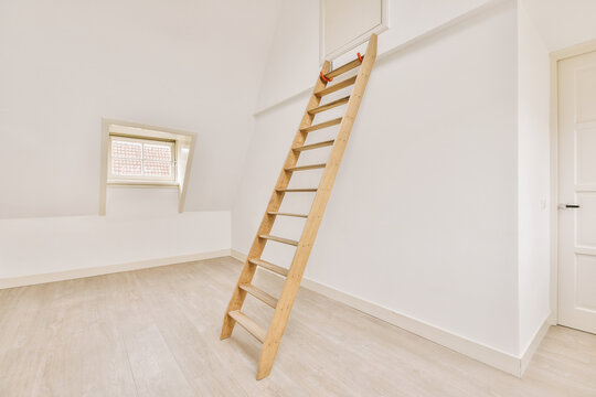 Empty mansard room with window and radiator