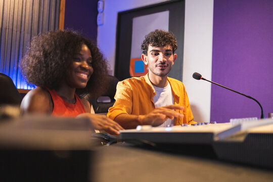 Man and black woman adjusting recorded sound