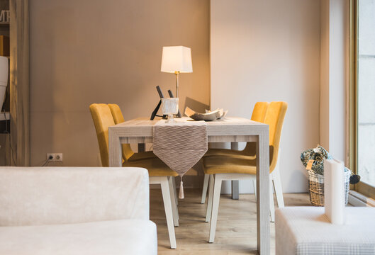 Dining zone with cushioned chairs table and lamp placed under lights