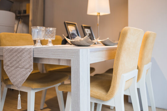 Dining zone with cushioned chairs table and lamp placed under lights