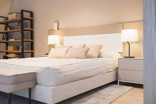 Modern bedroom interior with bed pillows side lamps shelves under lights