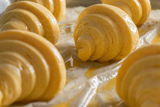 Sets of raw croissant with butter on table with white polythene cover