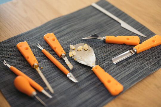 Set of Halloween pumpkin carving tools placed on wooden table