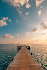 Obraz premium Beautiful seascape long jetty pier at sunset. Minimal sea sky, calm water surface and reflections. Colorful peaceful sunrise tones orange, gold, blue. Tranquil relaxing panoramic inspire meditation