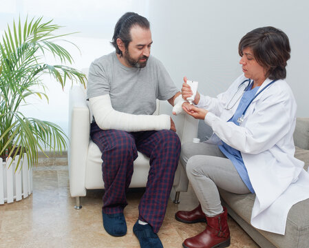 Woman applying antiseptic on injured hand of man