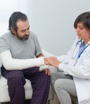 Woman applying antiseptic on injured hand of man