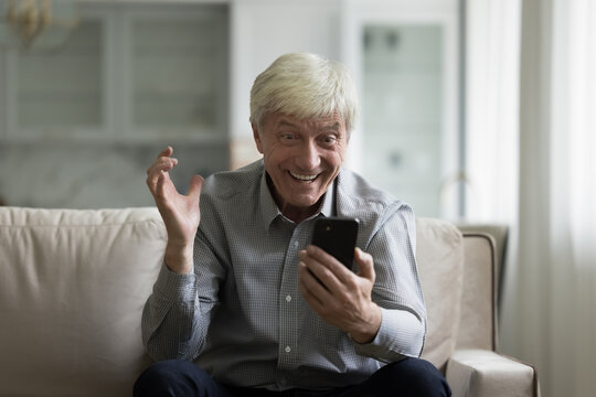 Excited Cheerful Old Mature Man Shocked With Good Amazing News, Staring At Smartphone Screen, Reading Notice, Message, Laughing, Shouting, Feeling Joy, Winning Money Prize, Getting Income