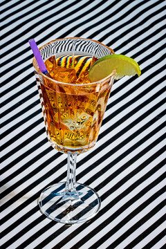 Cocktail glass decorated with lemon slice and straw served on table
