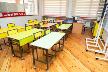 Empty school classroom with benches and tables