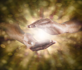Divine Intelligence the Creator of All That Is - male hands with white light between against an...